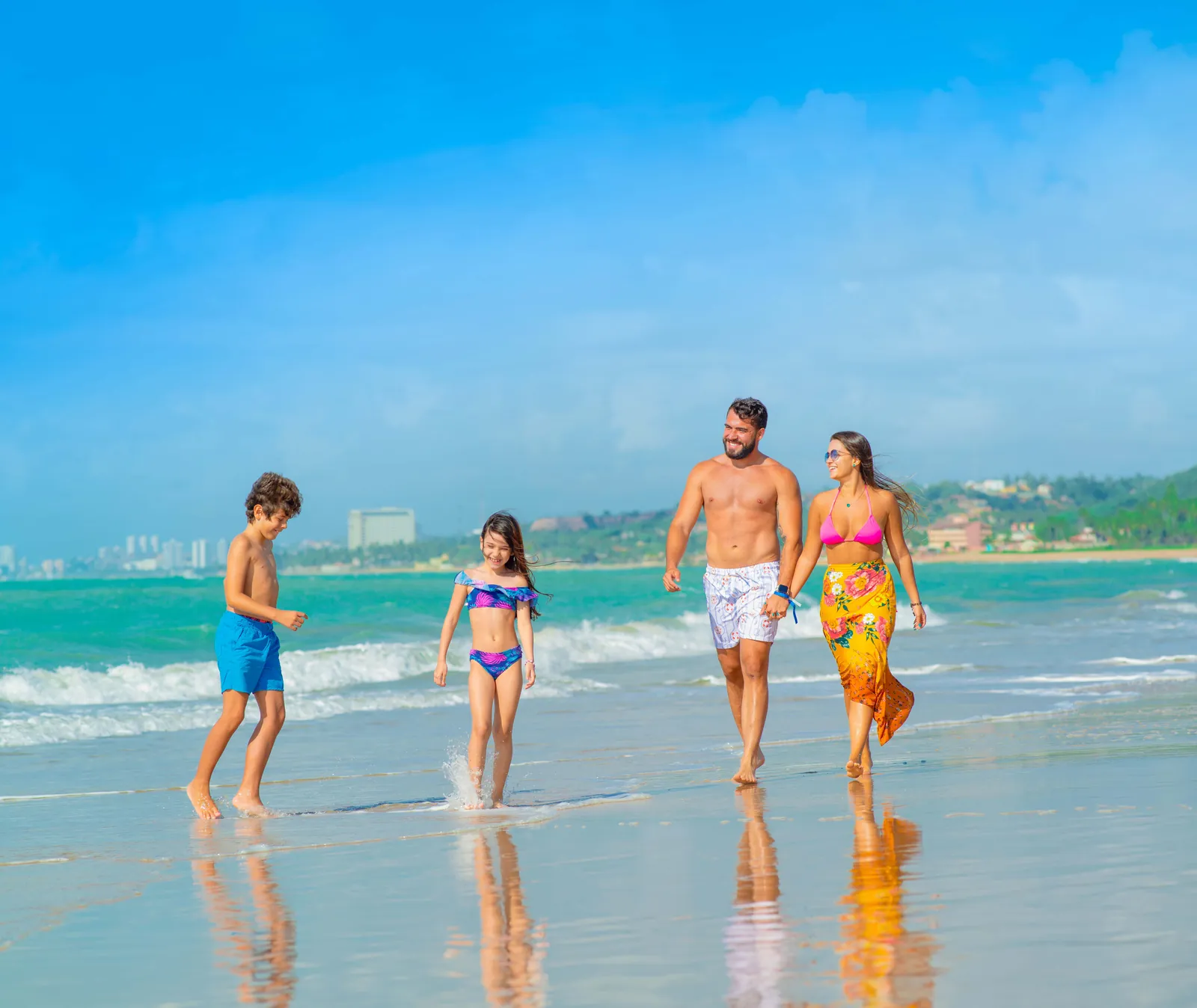 Família caminhando à beira-mar